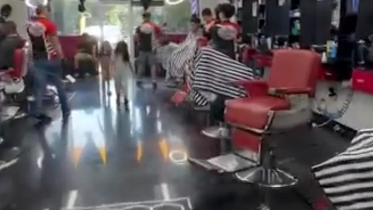 Barbers at work on the FinestCutz shop floor, with red barber chairs under hexagonal LED ceiling lights